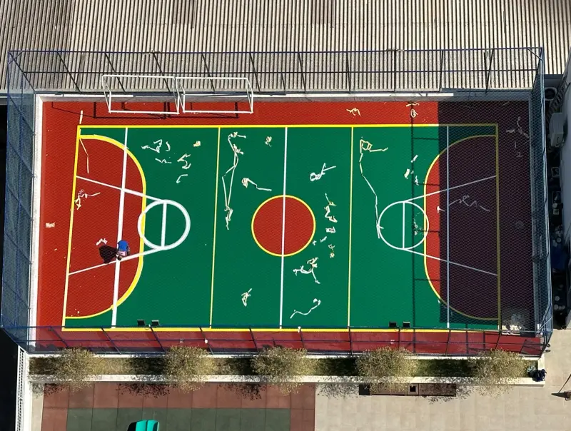Vista aérea de quadra pintada em verde, vermelho e amarelo